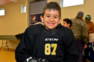 A participant in the New Canadian Hockey Program smiles with his new gear. 